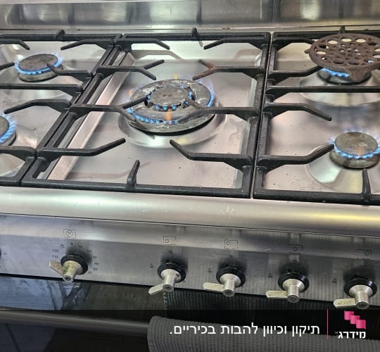 כיריים גז עם להבות פעילות במטבח.